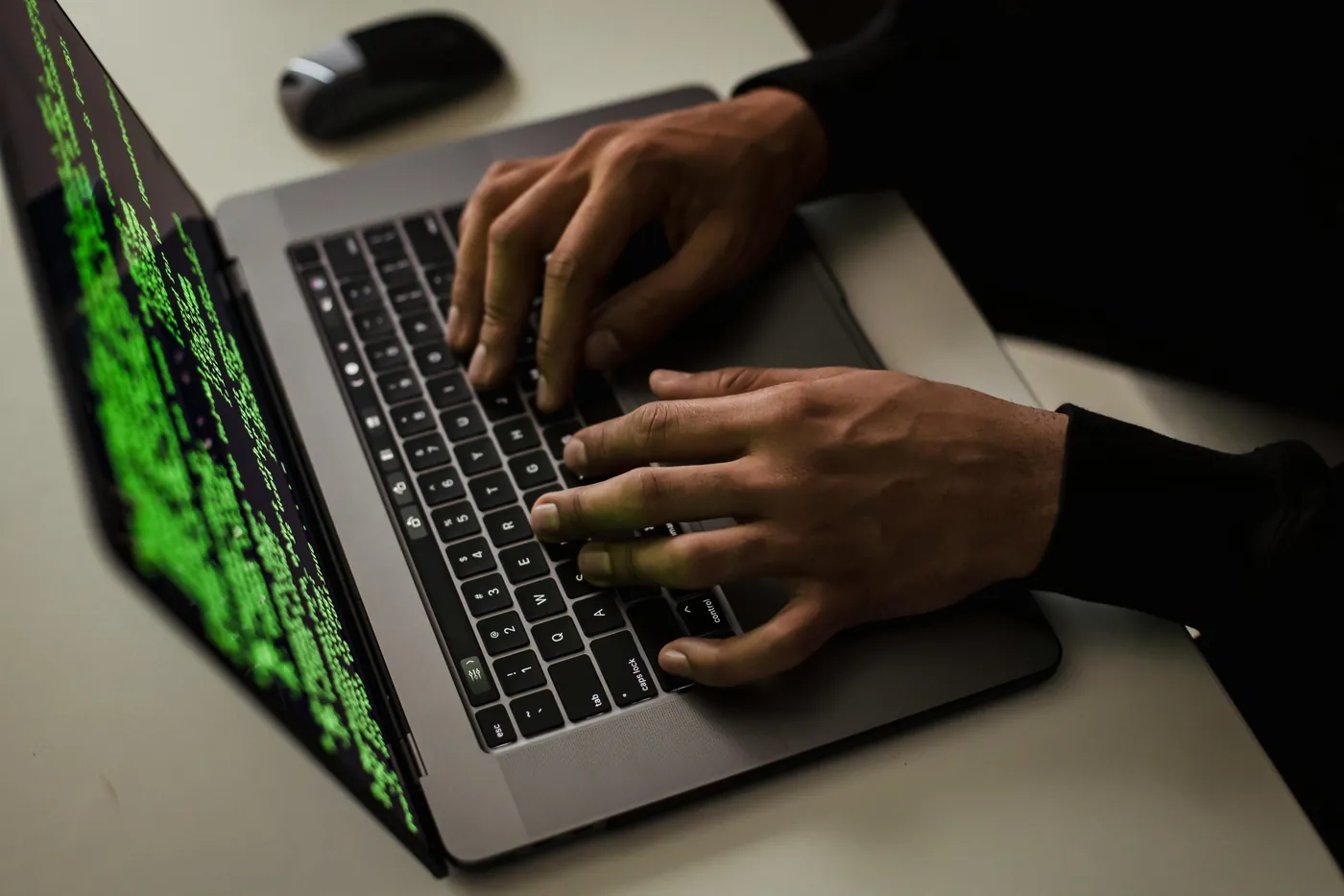 Hands typing on a laptop at night
